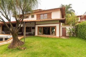 a house with a palm tree in the yard at Pousada Wafeh Pampulha Suítes in Belo Horizonte