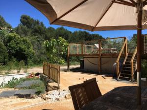 Un patio con sombrilla y zona de juegos en Rez-de-villa proche de la mer - Villa Temana, en Saint-Cyr-sur-Mer