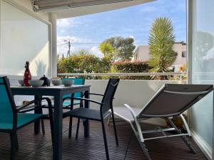balkon ze stołem i krzesłami na ganku w obiekcie 21 - Très agréable rdc avec terrasse et parking w mieście Bandol +17 zdjęć