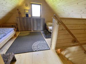 a attic room with a bed and a rug in a cabin at Słoneczna Osada Domki w górach na wyłączność in Kowary
