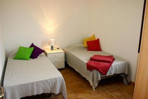 Pokój z 2 łóżkami i kolorowymi poduszkami w obiekcie Casa Livia Pool & Sunset w Corralejo +26 zdjęć