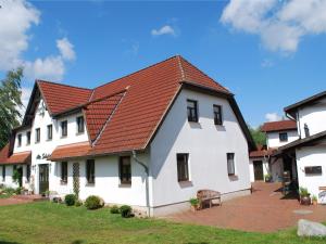 una gran casa blanca con techo rojo en Cozy Apartment in Dargun Mecklenburg with Swimming Pool en Barlin