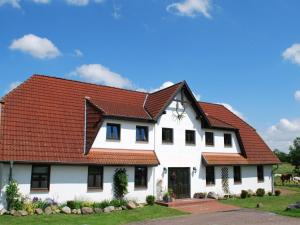 een wit huis met een rood dak bij Quaint Apartment in Dargun Mecklenburg with Swimming Pool in Barlin