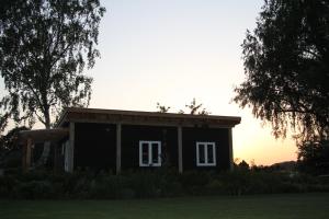 una pequeña casa sentada en la cima de un campo en Bed & Breakfast Bij de Wilg en Laren