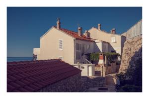 a white house with a red roof next to the ocean at Condo with a breathtaking view in Dubrovnik
