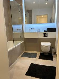 a bathroom with a toilet and a tub and a shower at Modern 2 bedroom Flat near King’s cross. in London