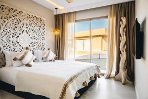 een slaapkamer met een groot bed en een groot raam bij Tulum Beach Resort Dakhla in Dakhla