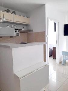 a kitchen with white cabinets and a white floor at Apartament Justyna in Kołobrzeg