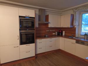 a kitchen with white cabinets and a stove top oven at Kaserer in Bruck an der Großglocknerstraße