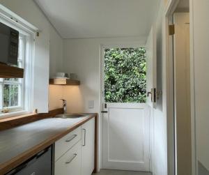 uma cozinha com uma porta branca e uma janela em Guest House at 118 by PWM Architects em Joanesburgo