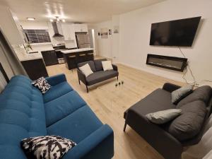 uma sala de estar com um sofá azul e uma televisão em The NW Olympic Retreat em Port Angeles