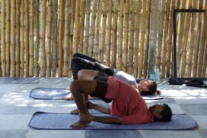 two people doing a yoga pose on the floor at Yoga Culture Palolem in Palolem