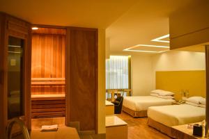 a hotel room with two beds and a bathroom at Ramada by Wyndham Mexico City Santa Fe in Mexico City