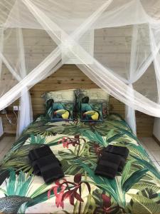 een slaapkamer met een groot bed met een baldakijn bij Kaz kad in Sainte-Rose