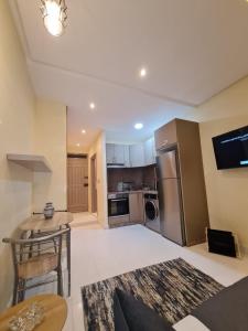 a living room with a table and a kitchen at Cozy Studio Private Terrace - fiber Wi-Fi & Netflix in Essaouira