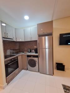 a kitchen with a stainless steel refrigerator and a dishwasher at Cozy Studio Private Terrace - fiber Wi-Fi & Netflix in Essaouira