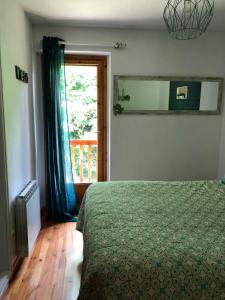 1 dormitorio con cama, ventana y espejo en Apartamentos Ca de Marti, en Bohí