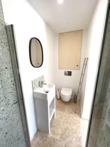 uma casa de banho com um lavatório, um WC e um espelho. em Cocon à l’orée de la forêt em Auriol