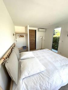 um quarto com uma grande cama branca e 2 almofadas em Cocon à l’orée de la forêt em Auriol