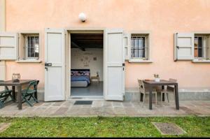 een patio met 2 tafels en een bank in een gebouw bij La camera di cavazzona in Cavazzona