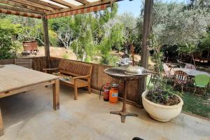 a patio with a table and a grill and a table at עין הוד בית בטבע עם בריכה שקט נוף מדהים להר ואדי והים in Ein Hod