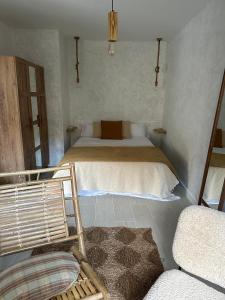 een kleine slaapkamer met een bed en een bank bij Casa Amodiño in Belesar