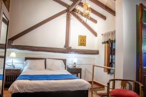 a bedroom with a bed and a chandelier at Hotel Casa de la Luz in Bogotá