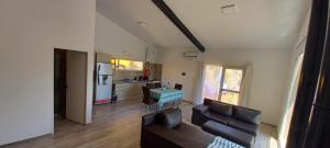 a living room with a couch and a table and a kitchen at Casa Las Lavandas - LOS REYUNOS in San Rafael