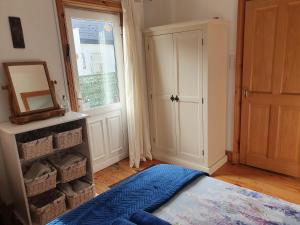 een kamer met een deur en een spiegel en een kamer met een raam bij Cosy self contained cottage with stunning views in Killaloe