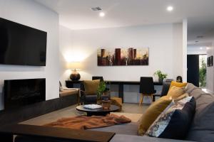 a living room with a couch and a tv at Kura Skymning- sleek Scandinavian design in Daylesford