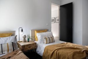 a bedroom with two beds and a mirror at Kura Skymning- sleek Scandinavian design in Daylesford