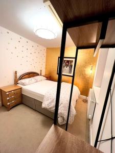 een slaapkamer met een bed in een kleine kamer bij Gold Penthouse - Near Basingstoke hospital 2min in Sherborne Saint John