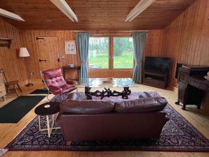 uma sala de estar com um sofá de couro e uma mesa em Spacious eco-energy timber barn in Chadbury em Offenham