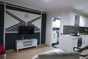 a living room with a tv and a kitchen at Daire Beşiktaş Merkez in Istanbul