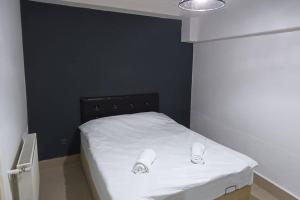 a bedroom with a white bed with a black wall at Daire Beşiktaş Merkez in Istanbul