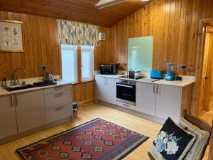 uma cozinha com electrodomésticos brancos e paredes de madeira em Spacious eco-energy timber barn in Chadbury em Offenham