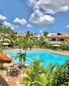 a large swimming pool with palm trees in a resort at Paraíso Bayahibe in Bayahibe