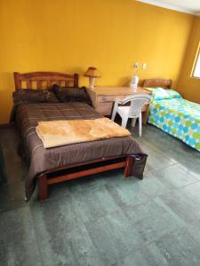 a bedroom with a bed and a desk and a bed and a table and chairs at Tapia house in Sucre
