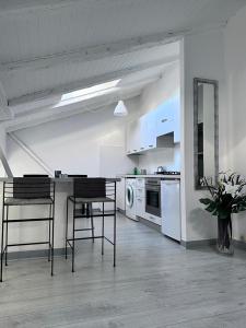 cocina con sillas, mesa y electrodomésticos en Angel, en Trieste