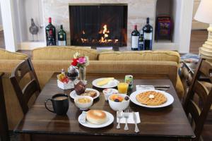 a table with breakfast food on it with a fireplace at Elm House Inn in Napa
