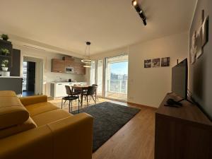 a living room with a yellow couch and a table at Torre Milano - Luxury modern flat in Milan