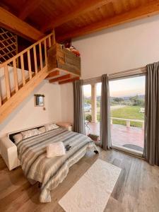 a bedroom with a bed and a large window at San Leonardo Country House in Calangianus