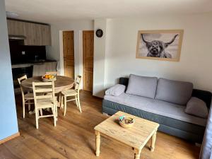 uma sala de estar com um sofá e uma mesa em Gîte des vignes em Bremis