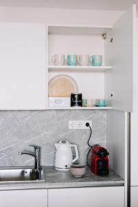 a kitchen counter with a sink and a tea kettle at Design Apartman - Free parking in Szeged