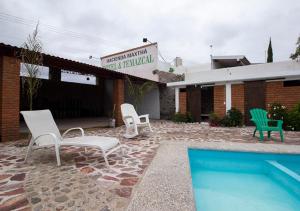 eine Terrasse mit Stühlen und einen Pool vor einem Gebäude in der Unterkunft Hotel & Temazcal Hacienda Maxthá in Huichapan