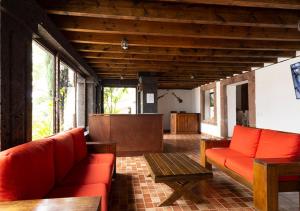 ein Wohnzimmer mit roten Sofas und einem Tisch in der Unterkunft Hotel & Temazcal Hacienda Maxthá in Huichapan