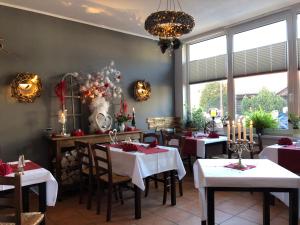 a dining room with tables with red and white table settings at Pension Mühlhahn in Schierke
