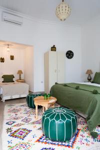 a living room with two green beds and a table at Riad Dar Blanche & Spa in Marrakesh