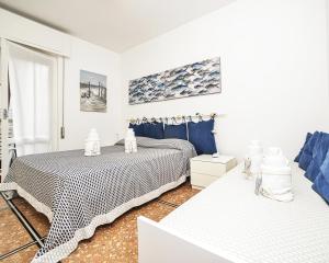 biała sypialnia z 2 łóżkami i oknem w obiekcie Appartamento Rapallo Liguria Maria Jose w Rapallo