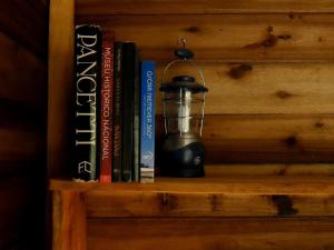 a book shelf with books and a lantern on it at Reserva Jacarandá Cabanas in Aiuruoca